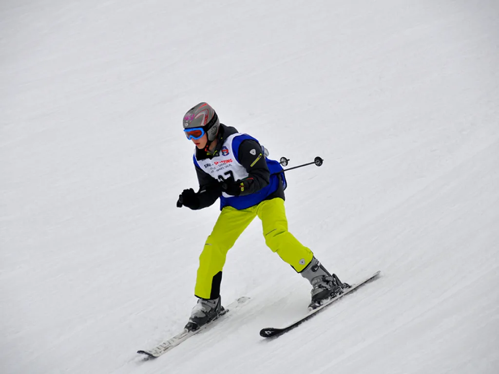 Snowboarder in gelber Hose zieht einen Schwung.